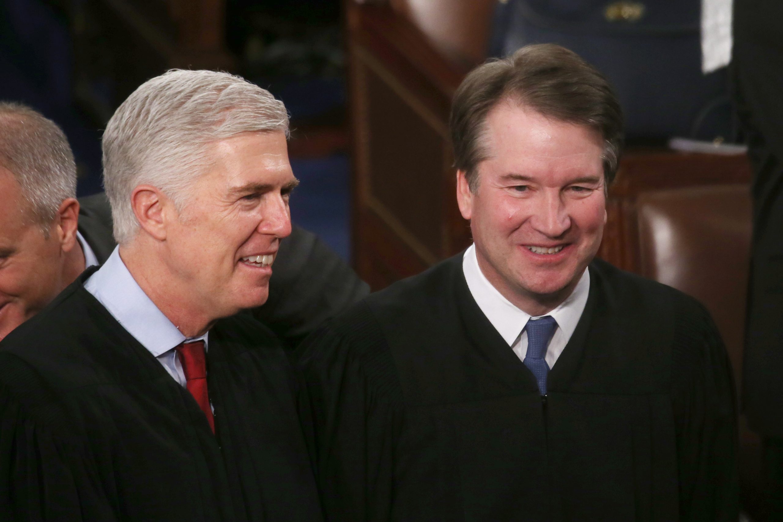 Two middle-aged white men wearing ties and black robes stand side by side smiling.