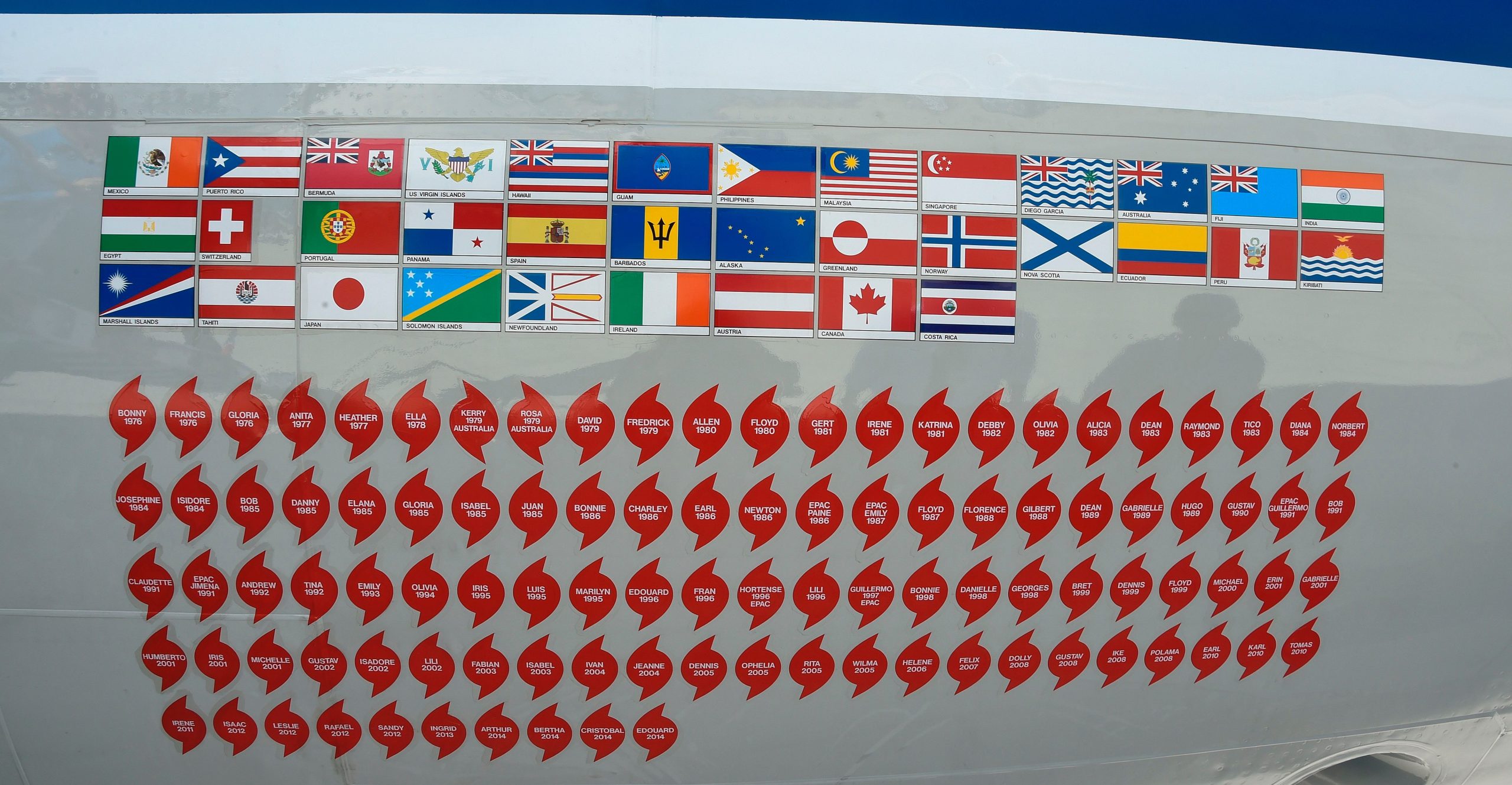 The nose of one of NOAA’s hurricane hunter aircraft displays long rows of stickers, around 100 of them in lines. The nose of one of NOAA’s hurricane hunter aircraft displays long rows of stickers, around 100 of them in lines.