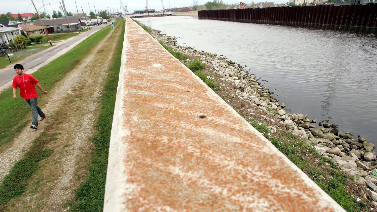 A pedestrian walks along the 17th Street Canal in 2007, near the levee wall that failed during Hurricane Katrina. 