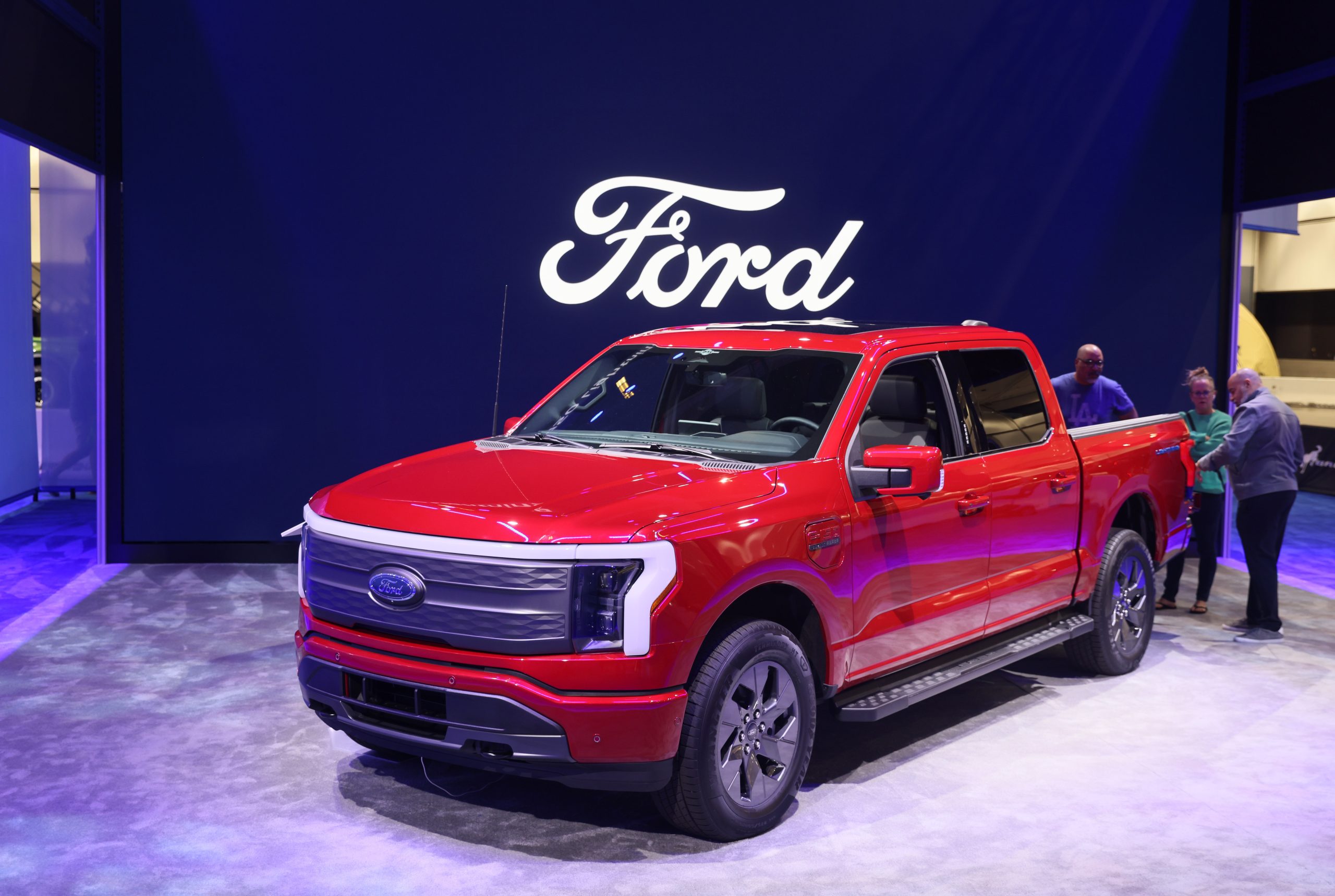 Red Ford F-150 Lightning on display at an auto show Red Ford F-150 Lightning on display at an auto show