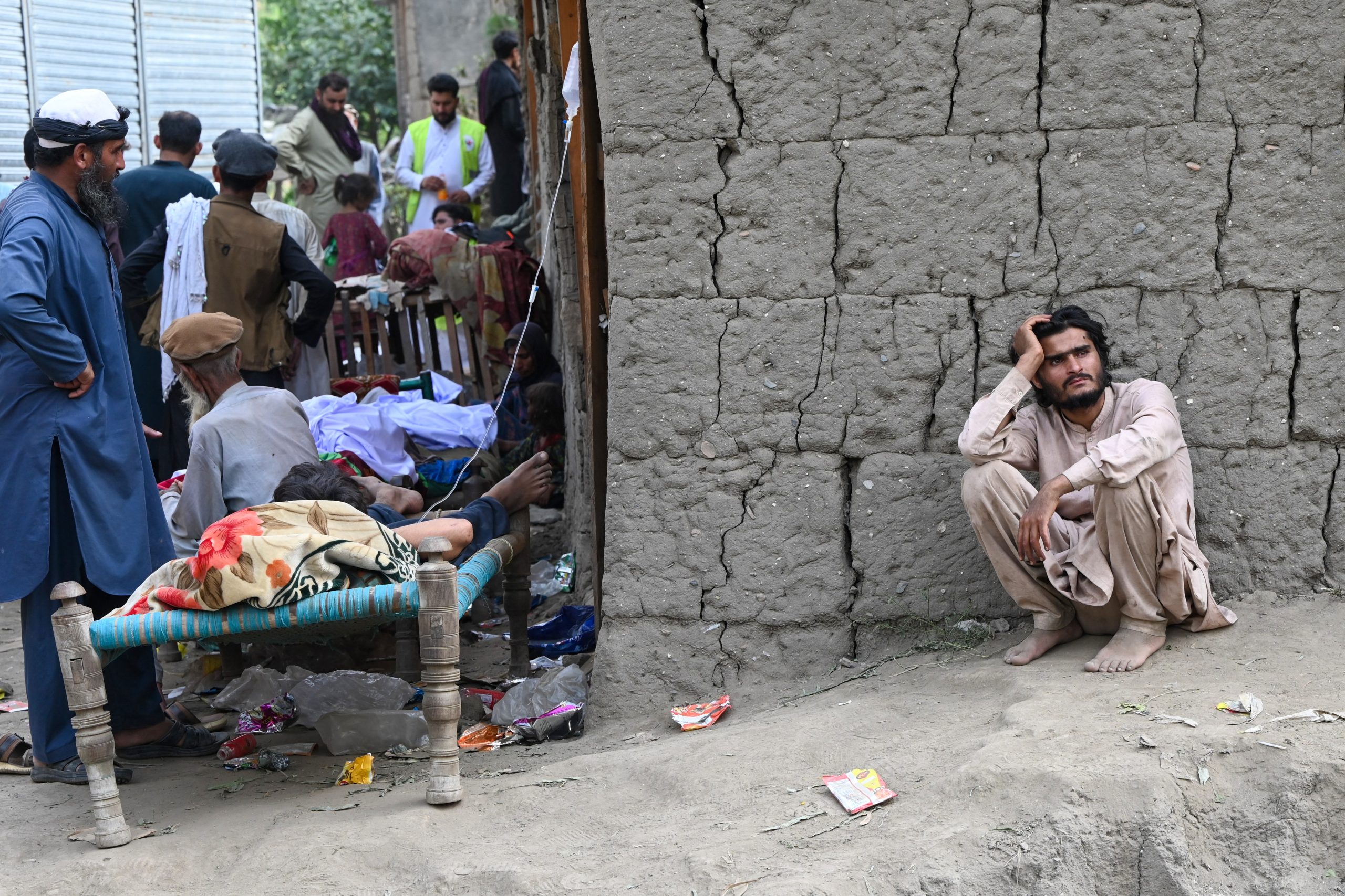 A man sits near a damaged building in Afghanistan after a magnitude 6.0 earthquake in Afghanistan