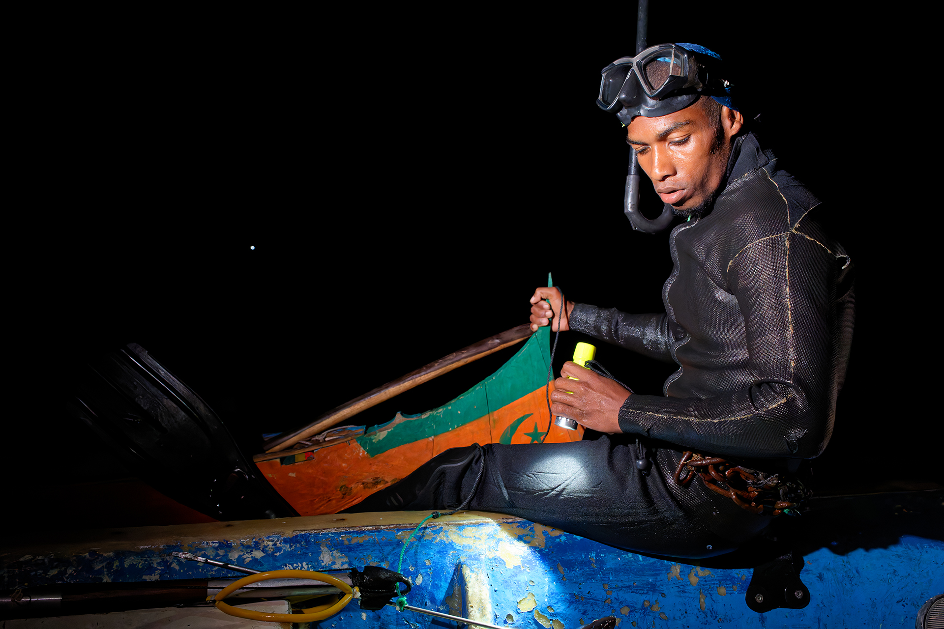 A diver flashing his light on hte eel he just caught A diver flashing his light on hte eel he just caught